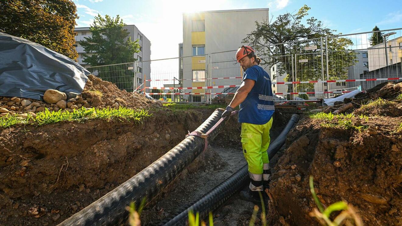 Brugg Pipes - Bild eines Arbeiters, der Fernwärmeleitung verlegt.